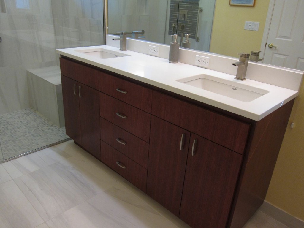 This solid surface countertop enhances the rich wood vanity.